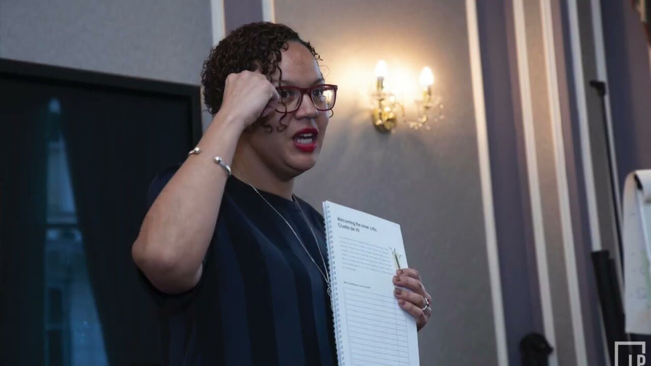 Keeley Taverner teaching a workshop group, workbook in hand