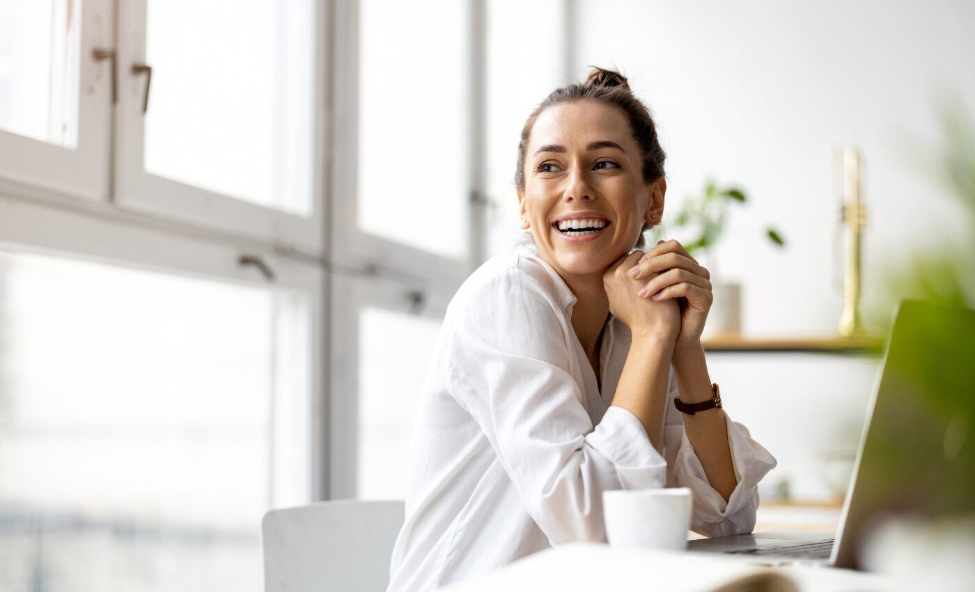 A woman smiling and looking towards the light, feeling hopeful and free